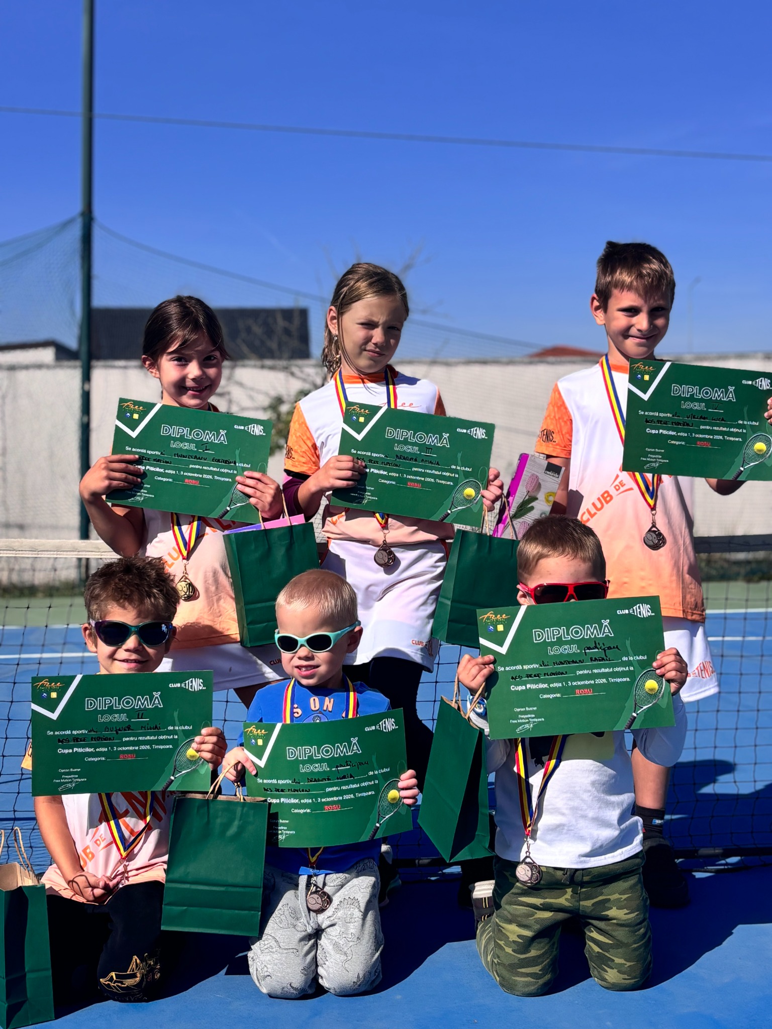 Grup de tineri jucători cu diplome la tenis