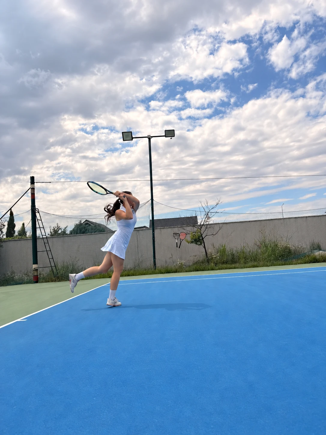 Jucătoare în timpul unei lovituri pe terenul de tenis